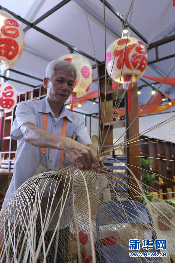 图为9月17日,在新加坡潮州节上,潮汕手工艺人现场编织潮汕油纸灯笼