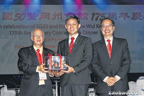 冈州会馆理事长周奕年(左)颁发纪念品给陈振声,旁为庆委会主席李国基(右)。(新加坡《联合早报》/程友明